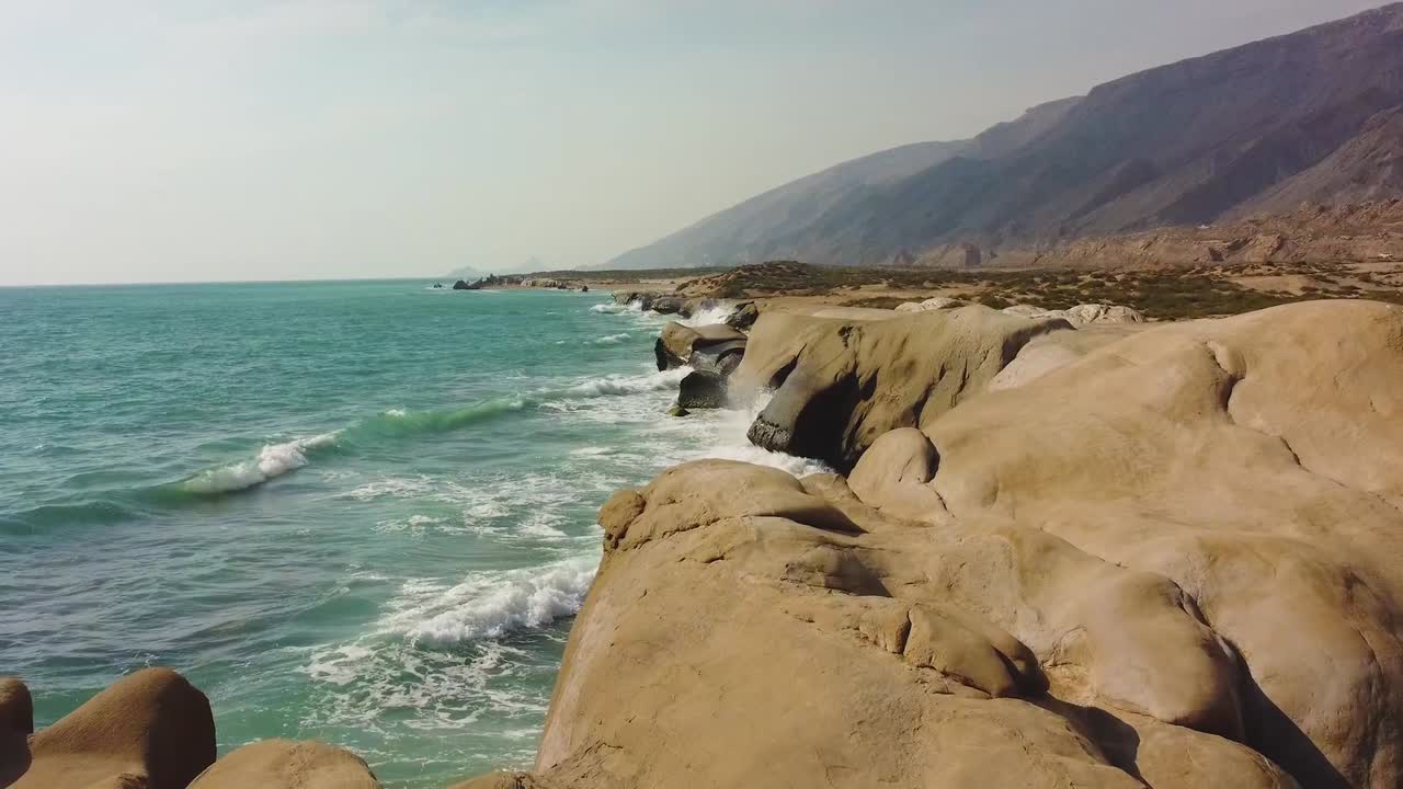 Smooth fly over the mud rough rocky beach in west coast Hormuz Island natural landscape of wonderful scenic sunset view skyline horizon water sport adventure trip camping near the beach pillar stone