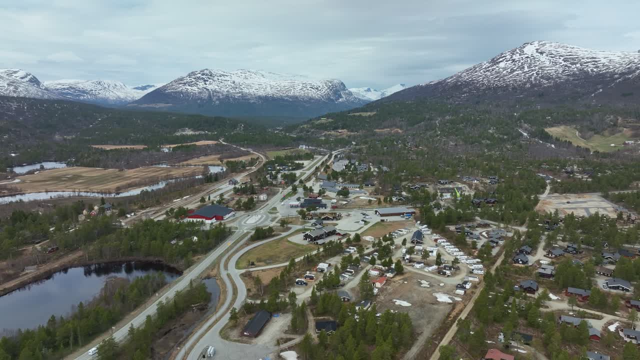vista aérea de bjorli noruega en primavera - árboles verdes con montañas cubiertas de nieve en el fondo