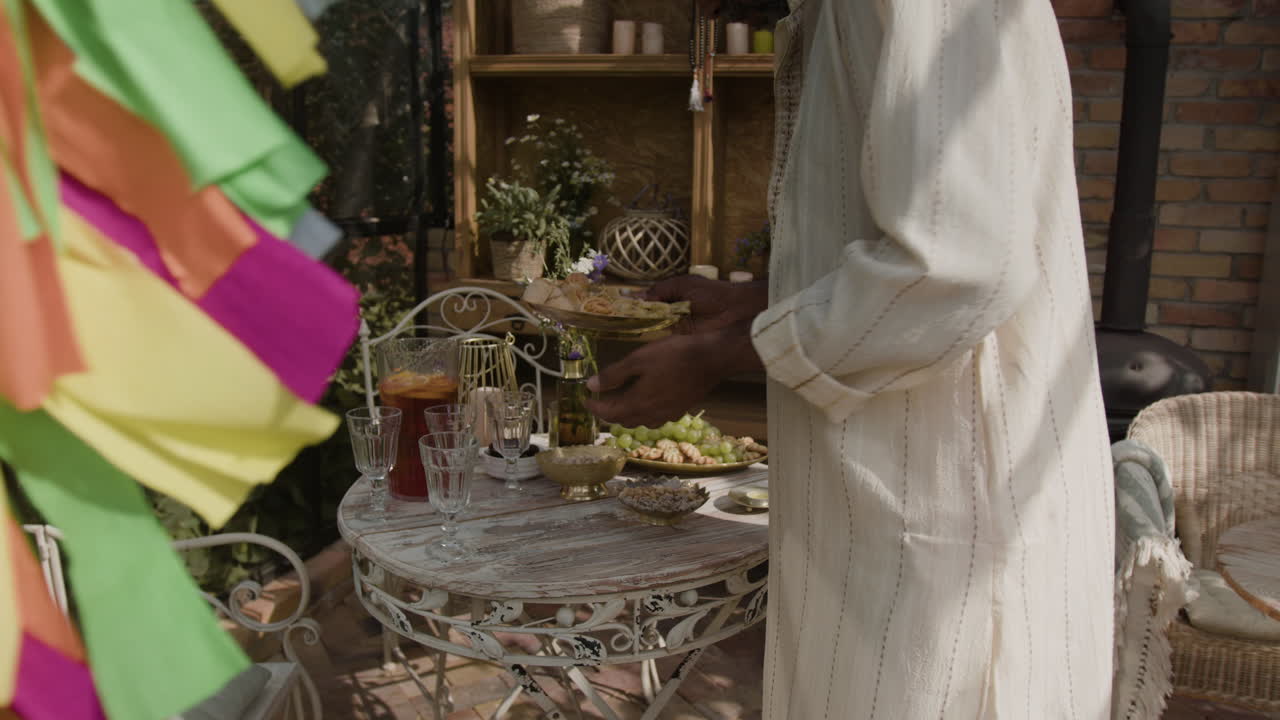 Man setting a festive table with snacks and beverages
