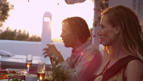 handheld close up of two couples eating dinner on a terrace, shot on r3d