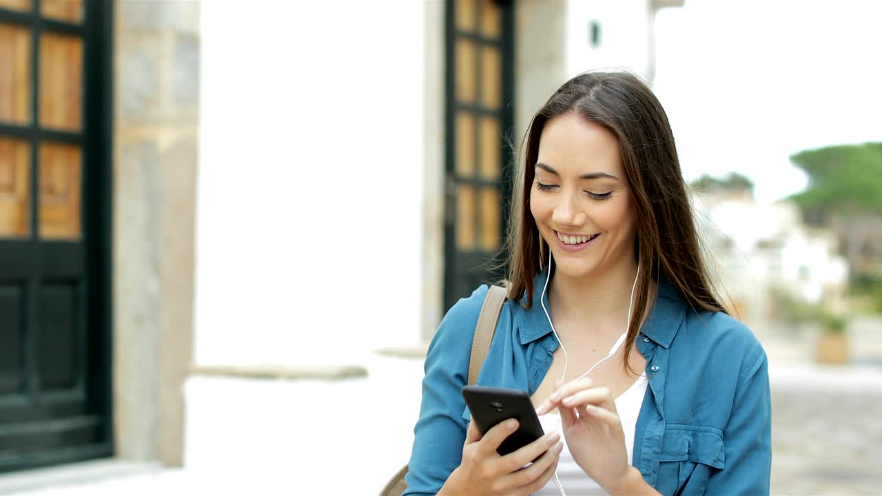 mujer feliz navegando y escuchando música en el teléfono