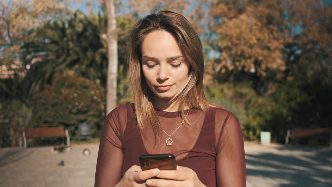 거리에서 전화로 문자 메시지를 보내는 여자.