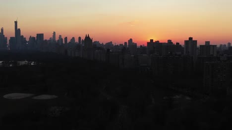 epic drone slide over the top of new york city's central park at gorgeous sunset golden hour