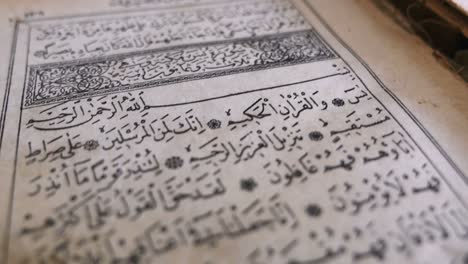 footage of an old quran, the shot is moving from the bottom to the top