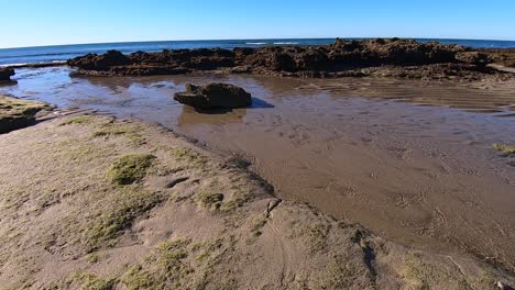 una amplia corriente de agua atraviesa la arena y la roca para regresar al océano, puerto peñasco, golfo de california, méxico