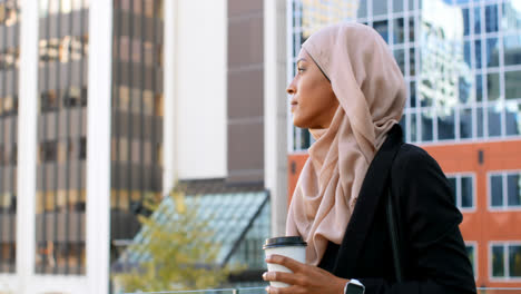 Vista-Lateral-De-Una-Joven-Asiática-Con-Hijab-Parada-En-La-Ciudad-4k