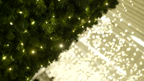 Close-up-of-Christmas-tree,-Christmas-lighting-in-background