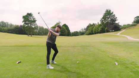 male golf player playing golf, hitting the ball with club on a golf course