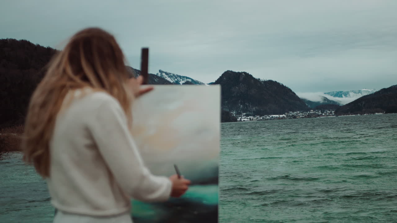 Woman Painting a Scenic Winter Landscape by the Lake