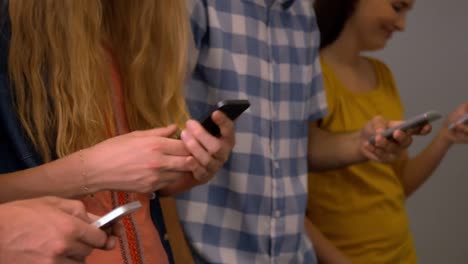 Students-using-their-smartphone-in-the-hall-of-the-university