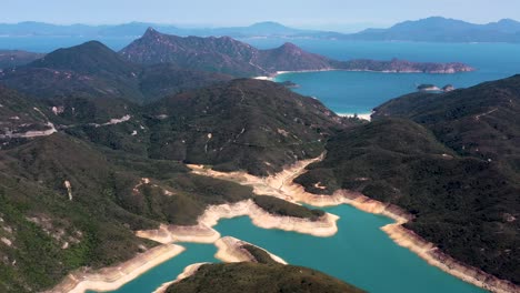 plataforma rodante aérea en el embalse de la isla alta colinas verdes columnas de roca en la costa y agua turquesa, península de san kung en hong kong, china