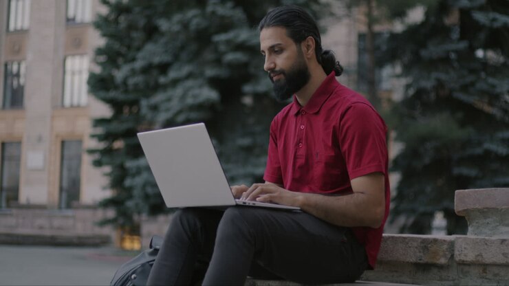 мужчина работает на ноутбуке на открытом воздухе