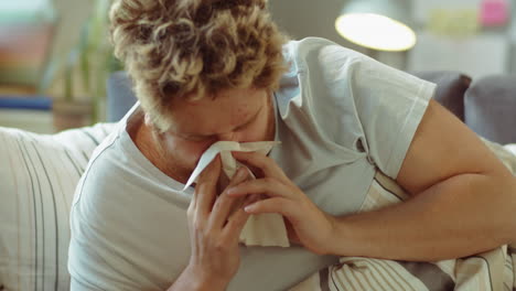 hombre enfermo estornudando y usando aerosol nasal en casa