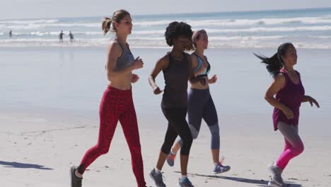 Multiethnische-Gruppe-Von-Frauen,-Die-Am-Strand-Und-Im-Hintergrund-Des-Blauen-Himmels-Laufen