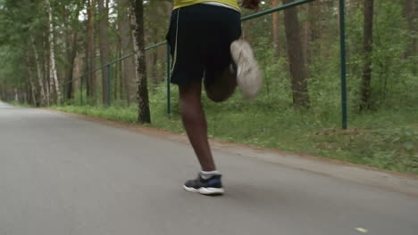 Camera-Focuses-On-Feet-Of-Man-Running-In-The-Forest