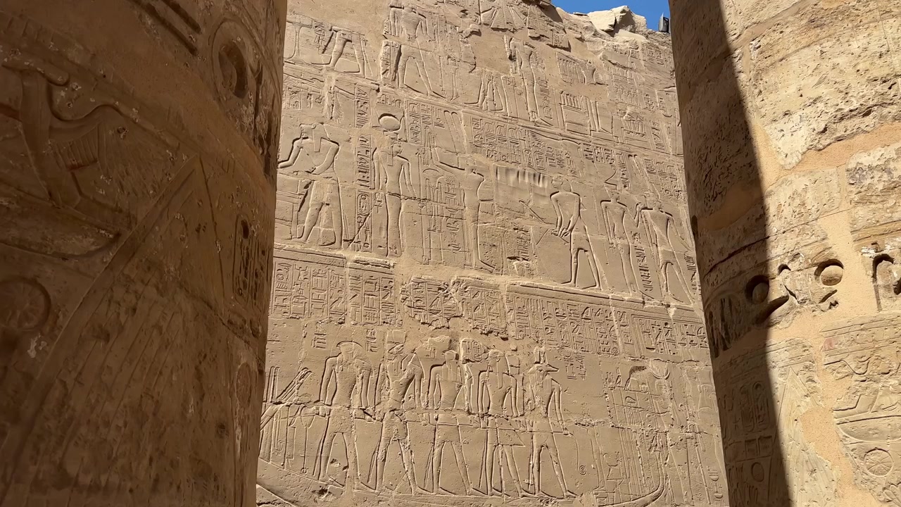 Rekaman panning sinematik relief dinding Mesir kuno di Kuil Karnak, menggambarkan adegan ritual, hieroglif, dan perahu suci.