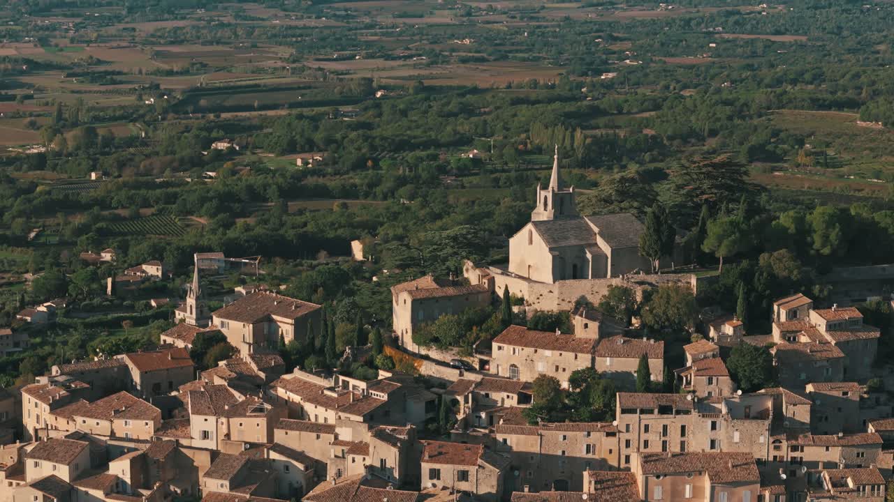 Aerial circle right pan up establishing of Bonnieux, Provence, France, capturing the village’s charming rooftops and surrounding countryside