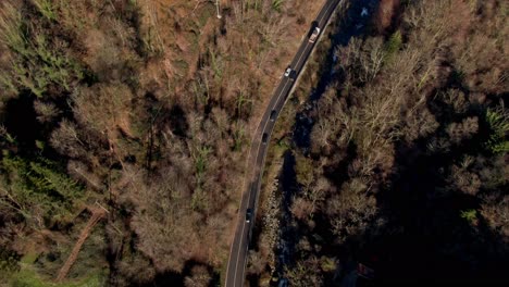 un dron aéreo sigue a los vehículos a lo largo de una pintoresca carretera italiana en un día de otoño crujiente