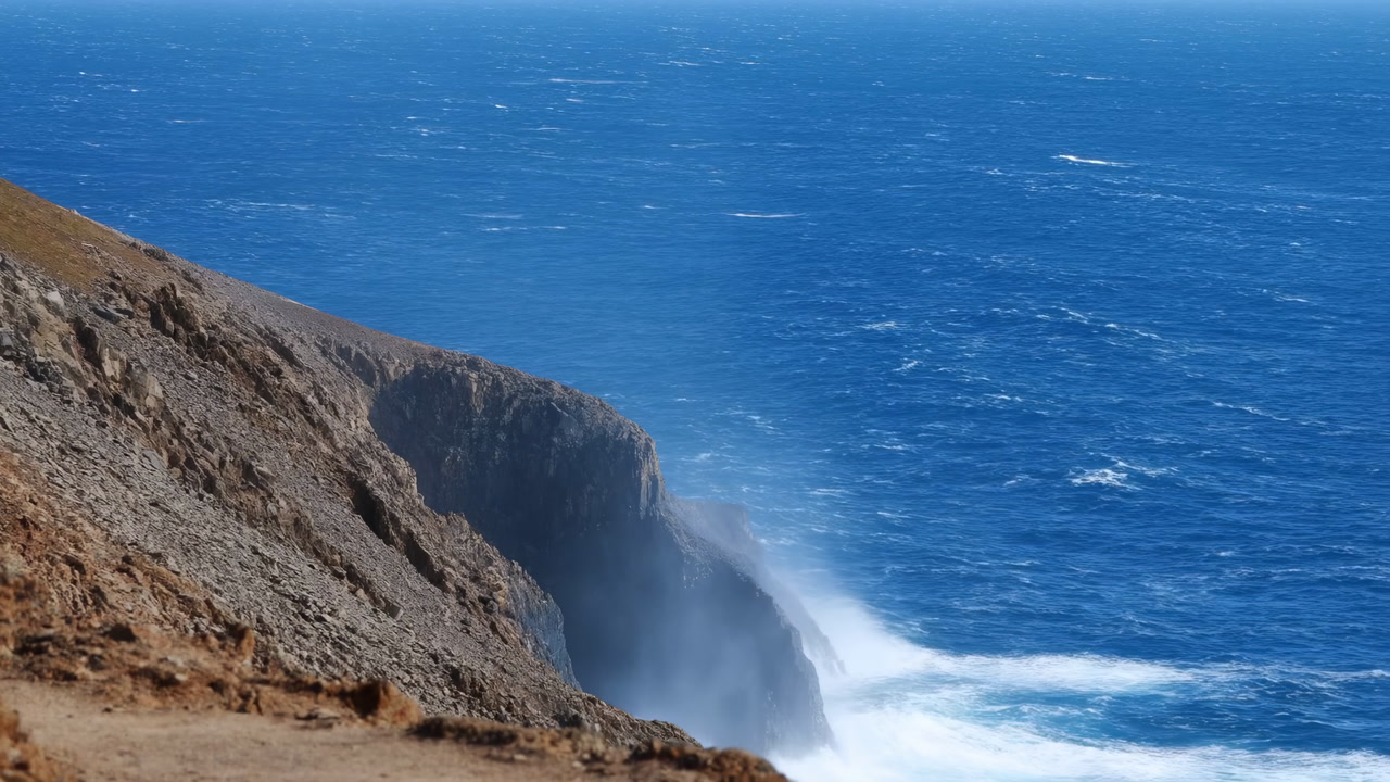 Rugged Coastal Cliff With Crashing Waves Windswept Grass And Deep Blue Ocean Powerful Surf Pounding Rocky