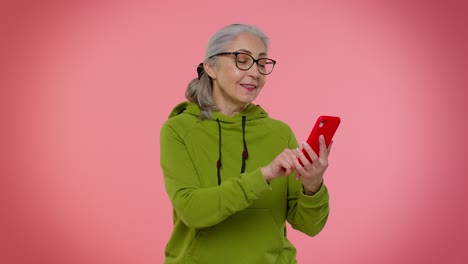 Senior-old-granny-woman-using-mobile-phone-typing-new-post,-sms-message,-browsing,-social-networks