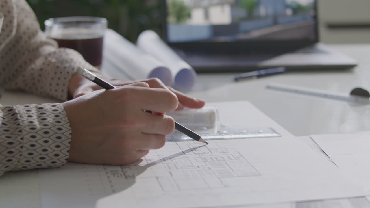 Hands of Architect Using Ruler and Pencil to Draw Floor Plan