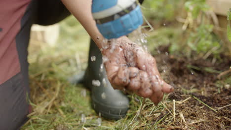 slomo - a hose is used to wash asian hands during planting in a greenhouse