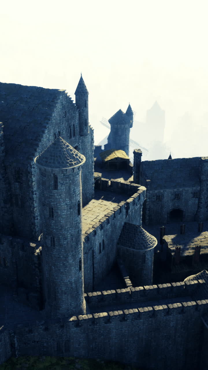 Imposing medieval castle surrounded by misty hills and windmills