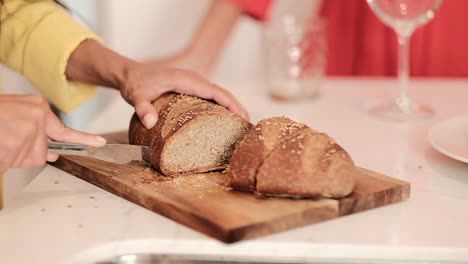 Crop-woman-cutting-bread-in-kitchen