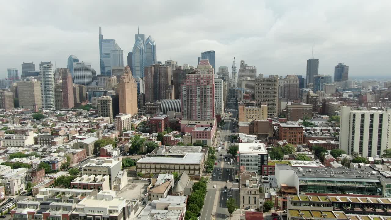 공중 풀백 샷은 흐린 여름날 시청을 향해 넓은 거리에서 북쪽을 바라보는 필라델피아 스카이라인을 보여줍니다.