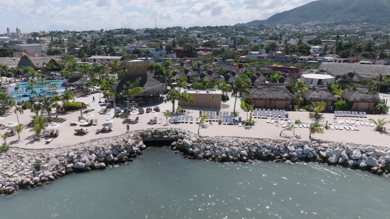 toma aérea de camiones de la bahía de taino con puerto plata y apartamentos de lujo con piscina