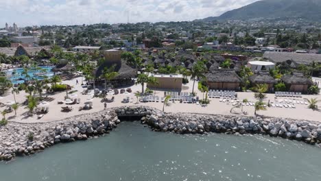 aerial trucking shot of taino bay with puerto plata and luxury apartments with swimming pool