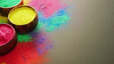 video of multi coloured powders and bowls with copy space on black background