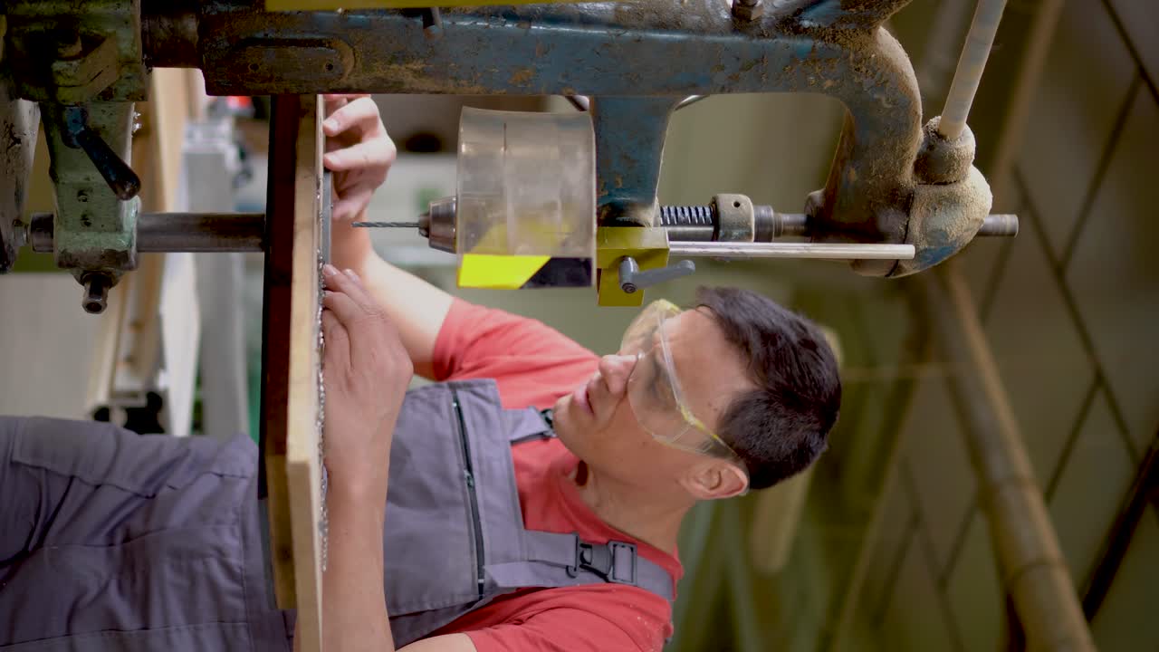 Man operating a drill press in a workshop