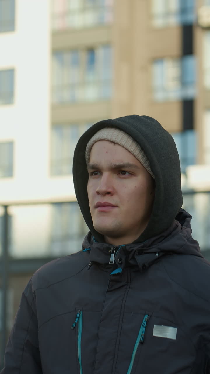 тренер бегает на открытой спортивной арене с сосредоточенным выражением лица, демонстрируя решимость, фитнес, настойчивость и преданность на фоне жилого здания и проволочной сетки