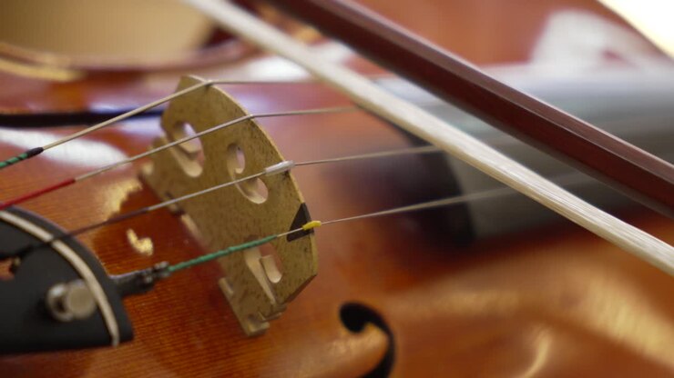 Primo piano dettagliato delle corde di un violino e dell'archetto in movimento