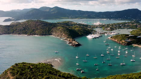 sunny aerial shot of english harbor in antigua, caribbean with views of yachts, sailboats, marina, bay and cliffs