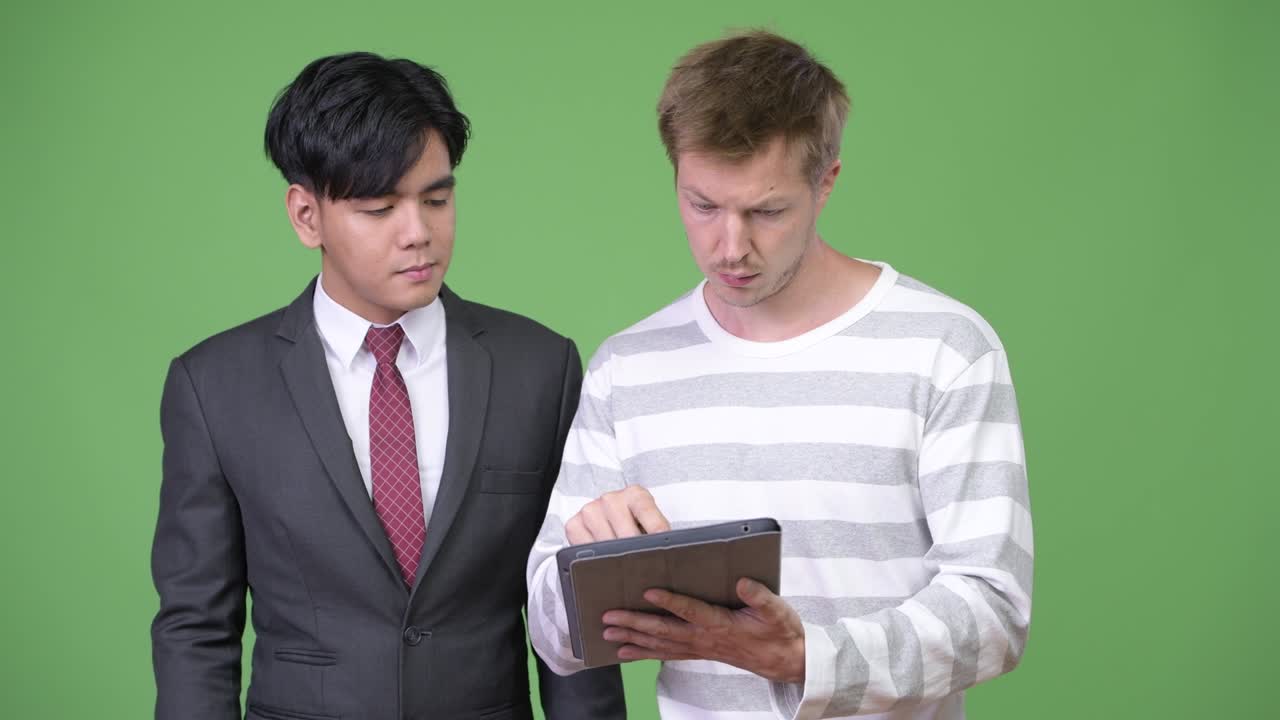 젊은 잘생긴 아시아 사업가와 젊은 스칸디나비아 사업가가 함께 일하고 있습니다.