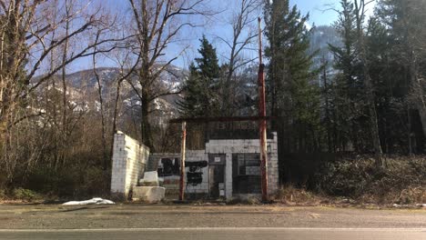 man skateboarding past old building in the forest