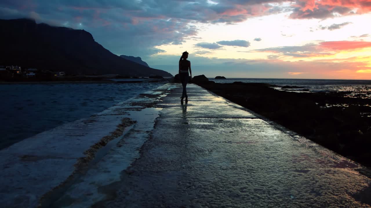 Woman walking on promenade at beach during dusk 4k