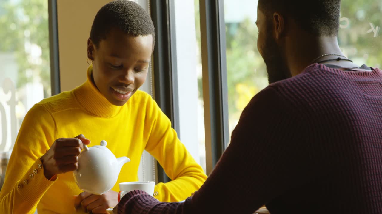 pareja interactuando entre sí mientras preparan café 4k