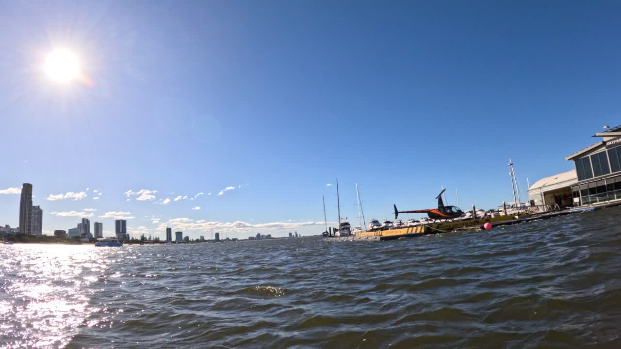 도시 스카이라인 근처의 물 위를 날아다니는 헬리터