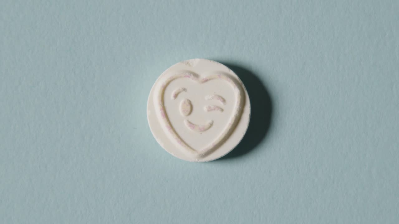 파란색 배경에 윙크하는 이모티콘이 있는 하트 캔디