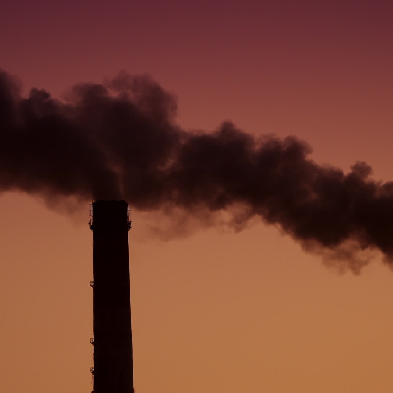 Air pollution by smoke coming out of two factory chimneys. Aerial view.