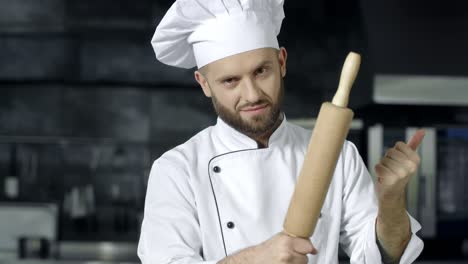 chef man posing with roller at kitchen. chef preparing to cook at kitchen.