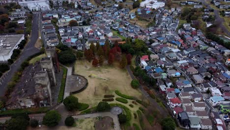 A-suburban-landscape-with-houses,-trees,-and-a-park,-cloudy-day,-aerial-view