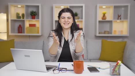home office worker woman experiencing joy looking at camera.