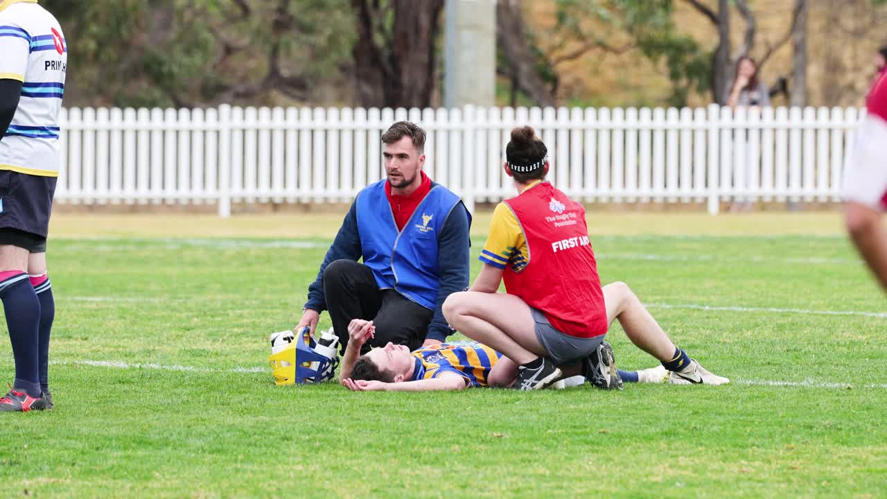 부상당한 럭비 선수 를 돌보는 의료진 들