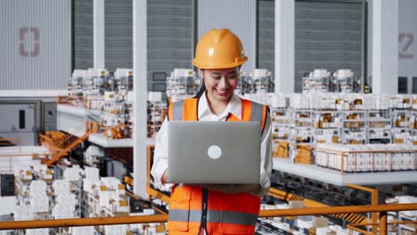 woman engineer working on laptop in a warehouse