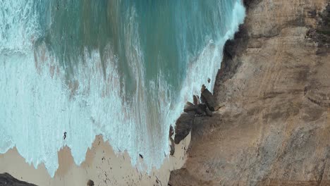 Vertical-zoomed-shot-of-Diamond-Beach-on-the-island-of-Nusa-Penida-Bali-showing-the-white-sands,-blue-water-and-waves-crashing-on-the-beach