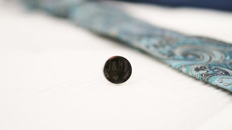 bokeh shot of an engraved cuff link with initials on the piece